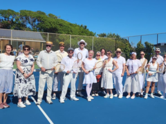 Plimmerton Community Tennis members dressed in 1920s-style clothing pose with wooden tennis rackets on the club courts during centenary celebrations.
