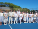 Plimmerton Community Tennis members dressed in 1920s-style clothing pose with wooden tennis rackets on the club courts during centenary celebrations.