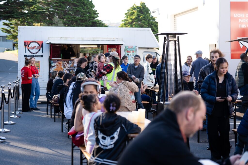 Visitors gather beside a food truck and outdoor tables at Porirua’s Bloody Good Night Market.