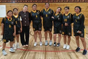 Porirua College senior girls’ basketball team posing in the gym.