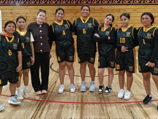 Porirua College senior girls’ basketball team posing in the gym.