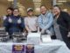Five women smiling behind a food stall with trays of island food at a Pacific Night Market in Cannons Creek.